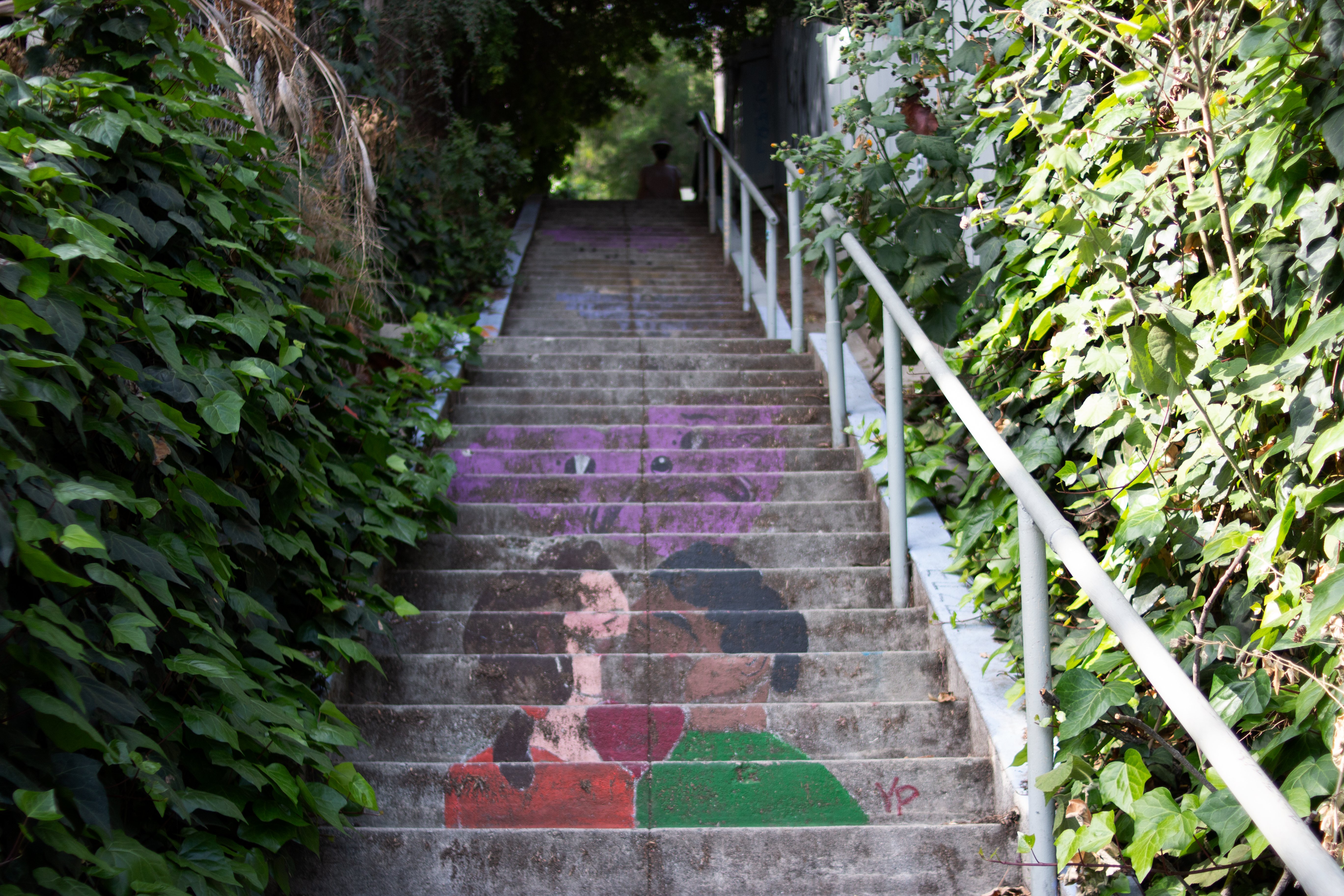 Faded painted staircase depicts couple kissing and crying hearts.